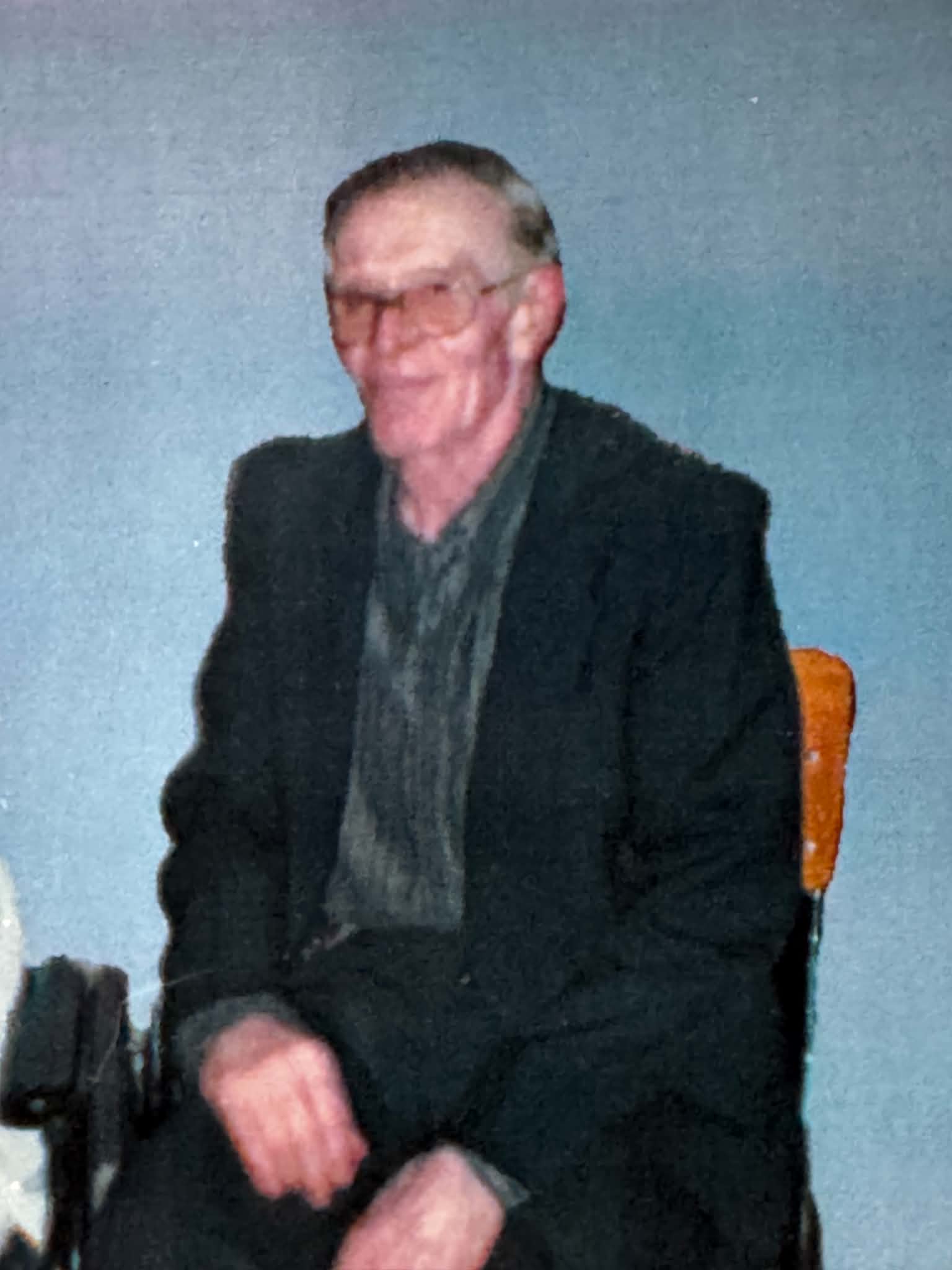Before: original portrait of a seated man wearing glasses