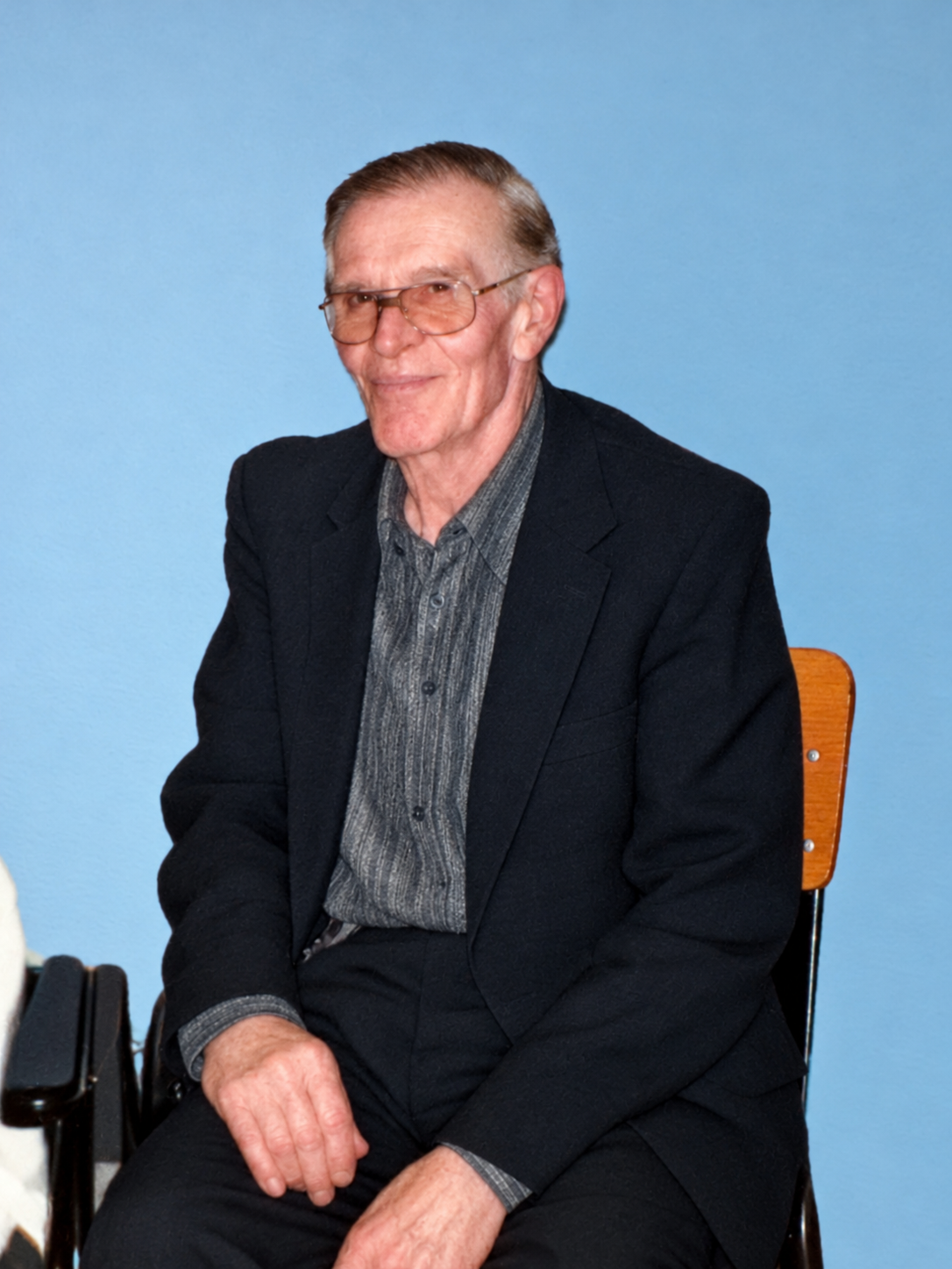 After: restored portrait of a seated man wearing glasses