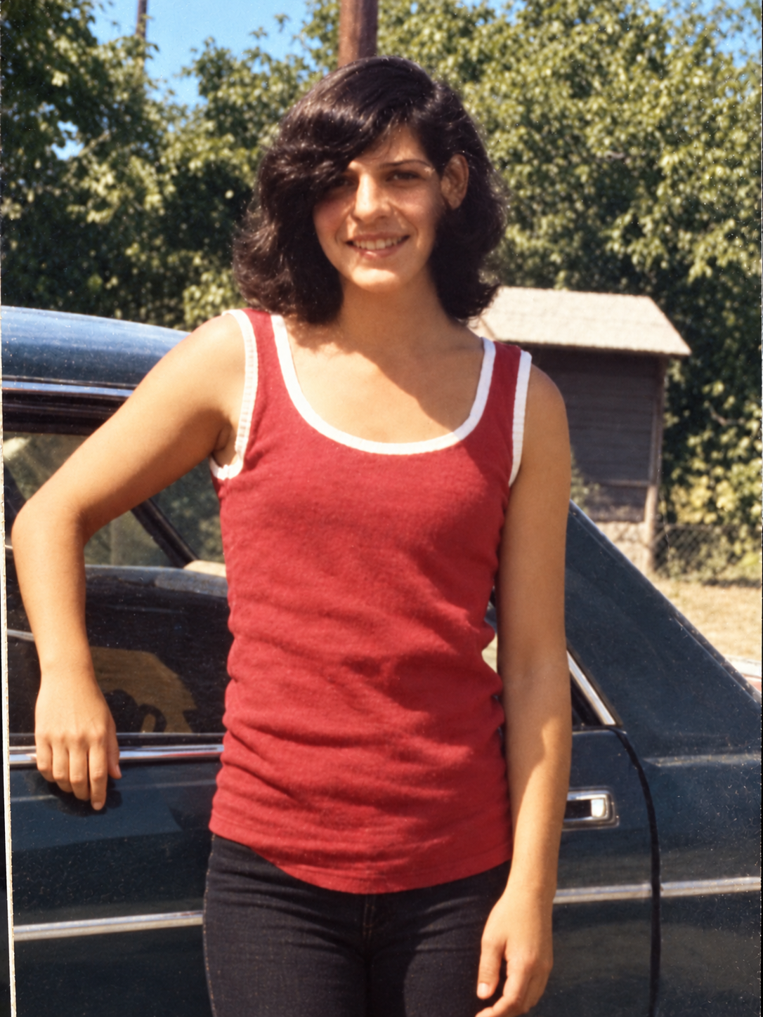 After: restored portrait of a person in a red top beside a car